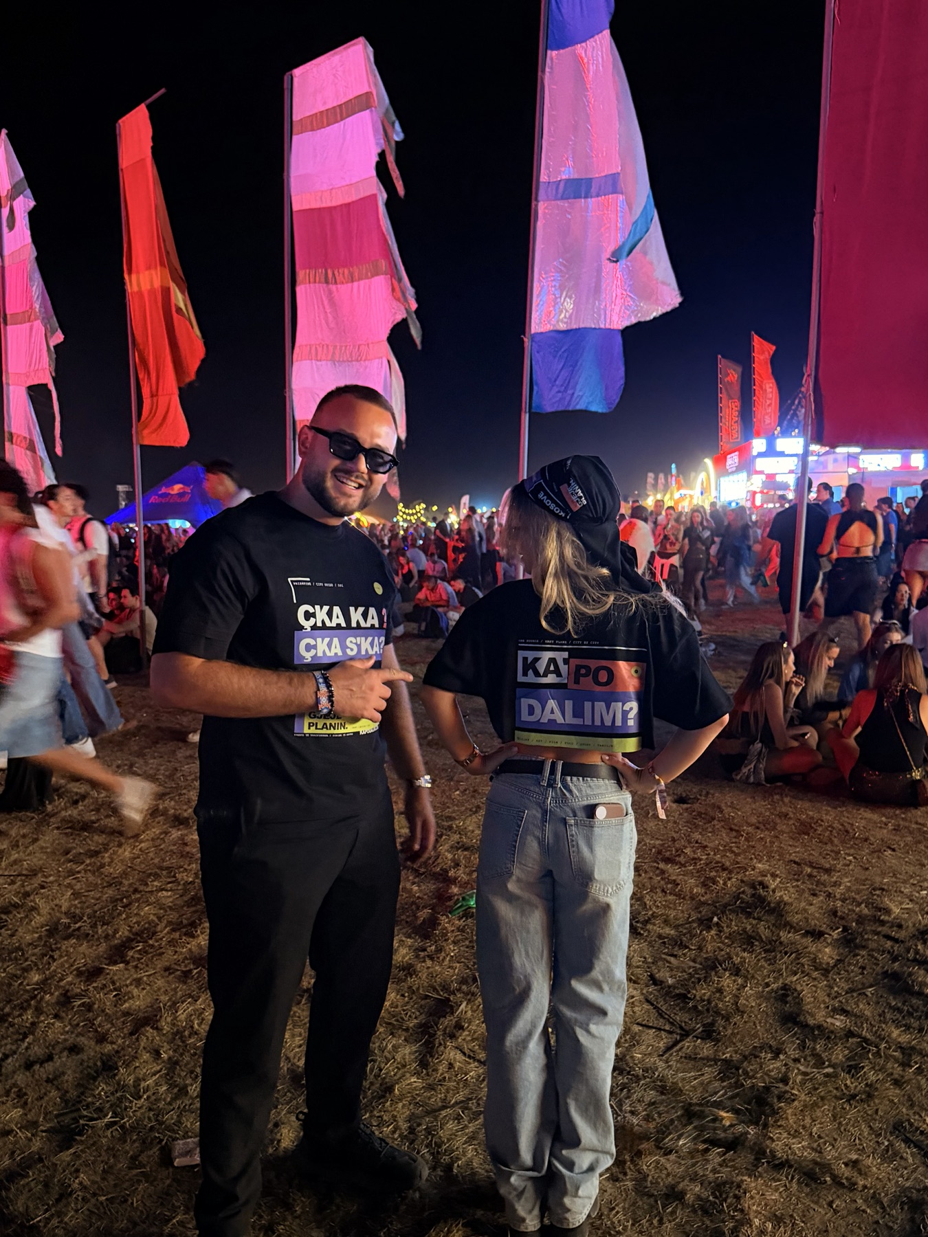 Two people at Sunny Hill showing the front and back prints of the RRUGA 01 T-shirt